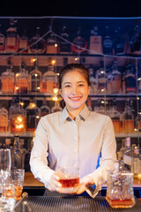 Professional female bartender preparing alcoholic drinks in a bar