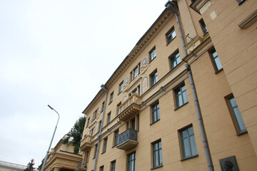 Fototapeta premium I gaze at a tall building adorned with balconies and windows