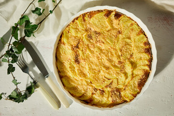 Deliciously baked gratin with golden crust served on a white rustic table