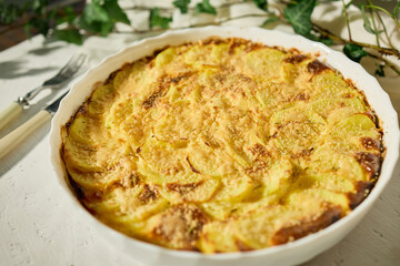 Deliciously baked gratin with golden crust served on a white rustic table