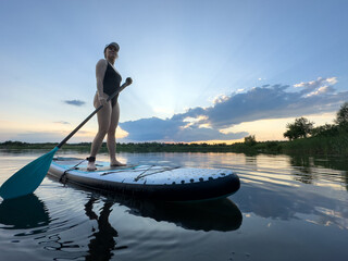 Paddleboarding at Sunset on a Tranquil Lake