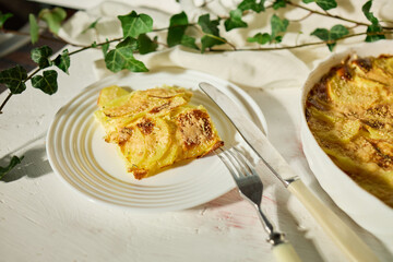 Delicious graten made with layers of sliced potatoes and cheese in a white rustic kitchen setting