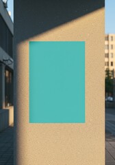 Photo of a blank teal poster is mounted on a concrete pillar in the city