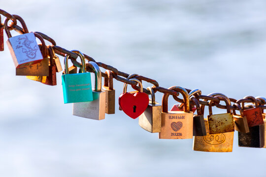 Love locks on a chain against cloudy sky