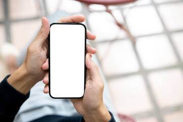 Close up of hand holding blank screen smartphone using application or social media on sidewalk bench