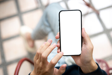 Close up of hand holding touching blank screen smartphone using application or social media on bench