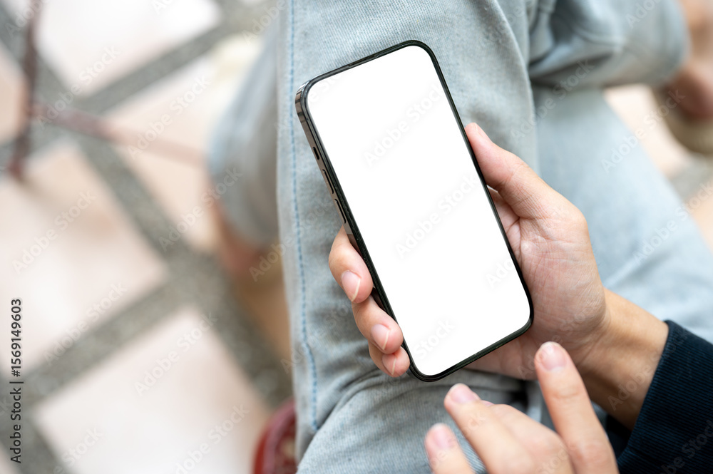Poster hand holding white screen smartphone over lap using application or social media while sits on bench.