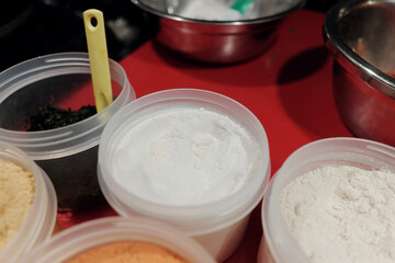 Vibrant seasoning powders on a red stall surface. While enhancing fried snacks, these are high in sodium & MSG, offering little nutrition. Excessive use can lead to an imbalanced diet.