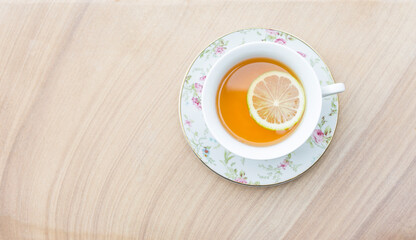Hot tea with lemon slice in flower tea cup on sand stone background, hot drink, healthy drink