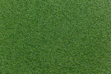 Close-up of artificial turf texture. Vivid green synthetic grass with visible fibers. Sports field...