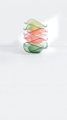 Elegant glass sculpture featuring stacked, colorful, translucent elements with smooth curves and layered design, displayed against a minimalist white background