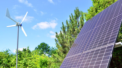 Solar panels with wind turbine on blue sky. Concept of clean energy. Green technology for future. 