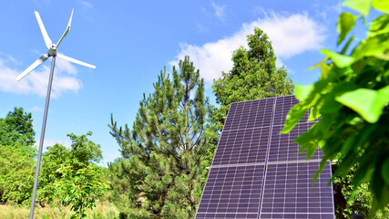 Solar panels with wind turbine on blue sky. Concept of clean energy. Green technology for future. 