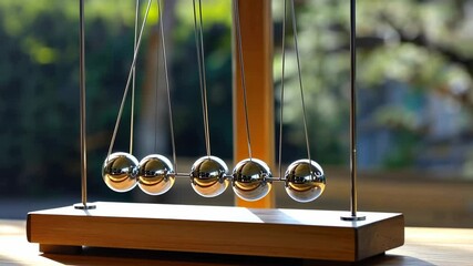 Wooden Newton's cradle with polished metal balls - Powered by Adobe