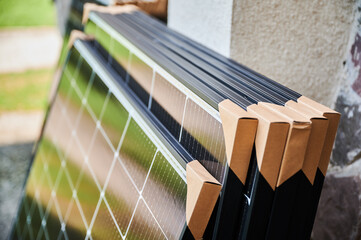 Close-up new solar panels with protective cardboard corners, ready for installation. Renewable...