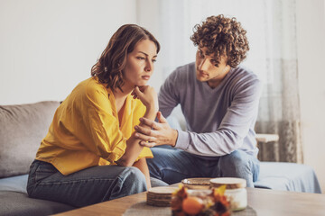 Man and woman are sitting at sofa and arguing. Relationship problems.