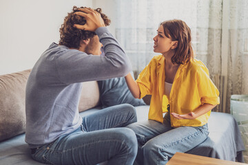 Man and woman are sitting at sofa and arguing. Relationship problems.