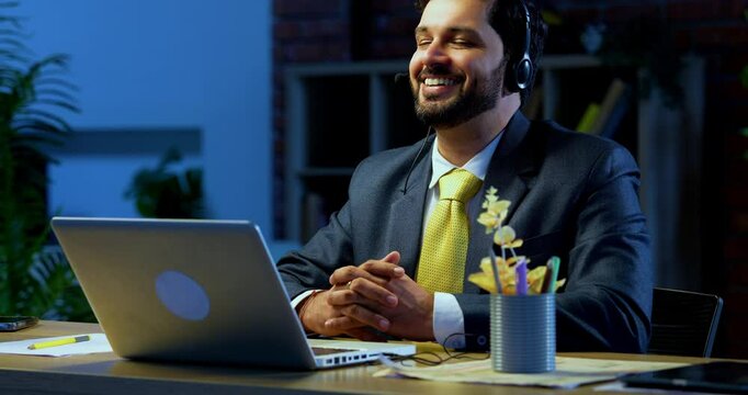 Indian businessman in call centre, Indian Asian corporate executive wearing headset and busy in communication, symbol of customer service, tech support, remote assistance, global connectivity