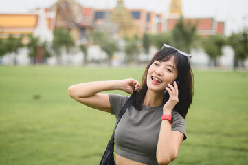 Happy southeast asian woman teenager blogger on solo world travel explorer tourism in Bangkok,...