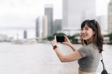 Happy solo southeast asian woman teenager blogger, world travel explorer in Asia, take photo with...