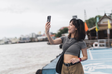 Happy solo Southeast Asian woman teenager blogger and world travel explorer on local cultural...