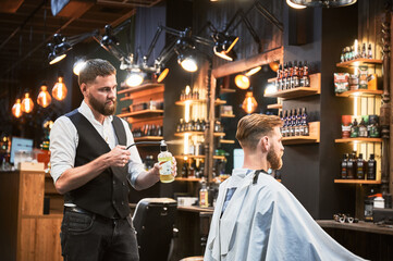 Professional barber spraying aftershave lotion on client's nape. Back view of fresh haircut from experienced hairdresser. Male hairstylist using special equipment for styling.