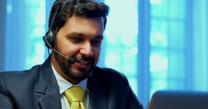 Indian businessman in call centre, Indian Asian corporate executive wearing headset and busy in communication, symbol of customer service, tech support, remote assistance, global connectivity
