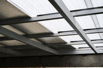 Obraz premium Gray metal framework supports translucent plastic sheet panels. Above insulation resembling foam adds to structure material. Construction potentially includes pu properties for durability