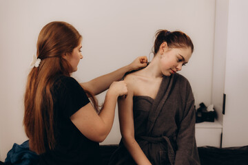 Beauty Specialist Assisting Client with Shoulder Examination in a Modern Practice Setting