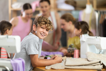 Portrait of happy teenage boy at sewing class