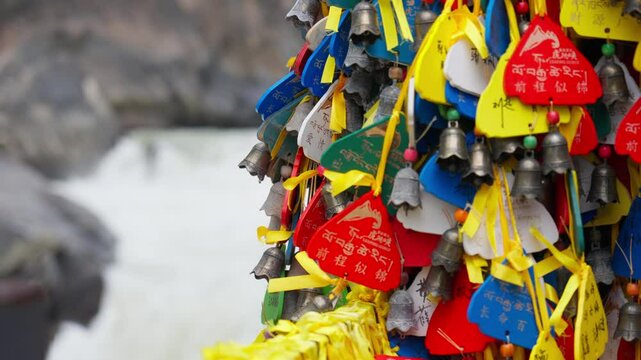 Triangular prayer tags with Hindi script hang alongside bells in a natural setting&mdash;capturing a moment of devotion, culture, and spiritual tranquility.