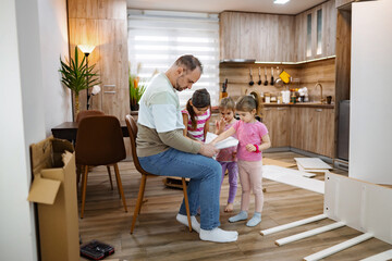Family bonding while assembling furniture in a cozy home