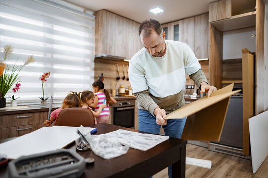 Father and daughters engaging in home improvement project together