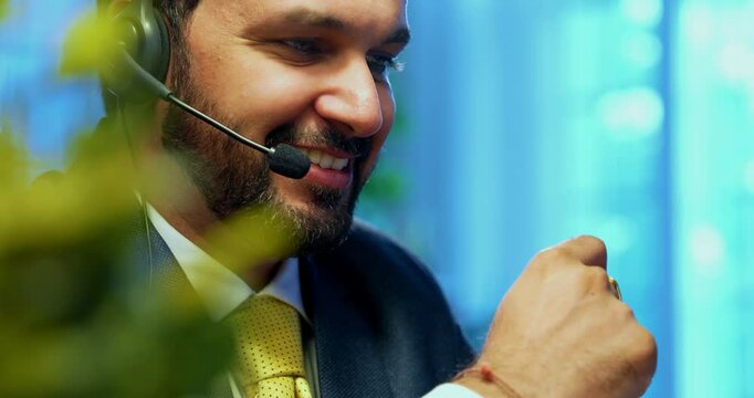 Indian businessman in call centre, Indian Asian corporate executive wearing headset and busy in communication, symbol of customer service, tech support, remote assistance, global connectivity