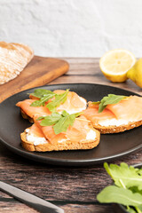 Smoked and salted salmon toasts served with arugula, healthy breakfast