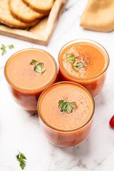 Fresh spanish cold tomato soup, gazpacho, served in small glasses.