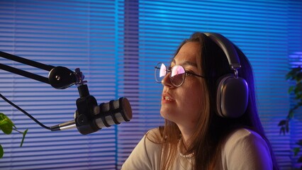 Young Woman in Studio with Microphone and Headphones Recording Podcast