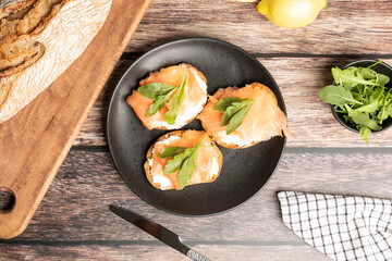 Top view of smoked and salted salmon toasts served with arugula