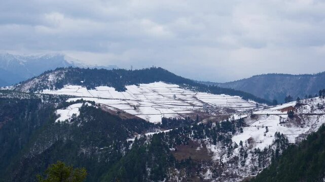 Majestic Haba Snow Mountain towers above forested terrain in Shangri-La&mdash;snowy peaks beneath a moody sky create a stunning portrait of Yunnan&rsquo;s alpine wilderness.