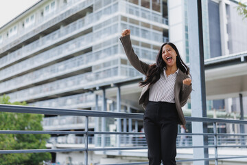 Fototapeta premium Excited businesswoman celebrating success in urban setting