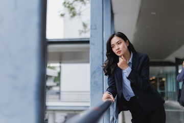 Fototapeta premium Pensive businesswoman leaning on railing while thinking about future projects