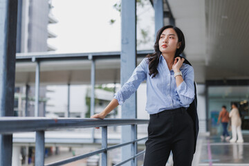 Fototapeta premium Businesswoman leaning on railing in modern office building