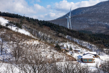 snow-covered mountain with wind turbine