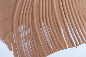 A sample of liquid foundation powder in a dark tone for tanned skin of the face and body. Cosmetic...