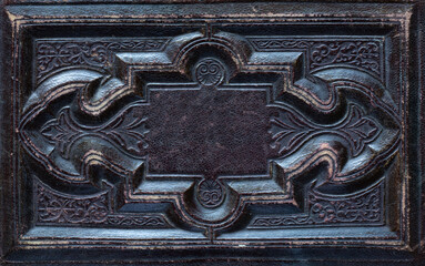 Old leather background. Fragment of a leather cover of an old book from the 19th century. Retro background on the theme of vintage, history, antiques.