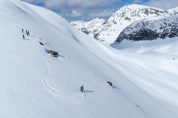 Alpine skiers in mountain. Group of downhill skiers on a slope on a bright sunny day. Norwegians...