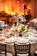 Elegant Wedding Reception with Floral Centerpieces and Golden Light