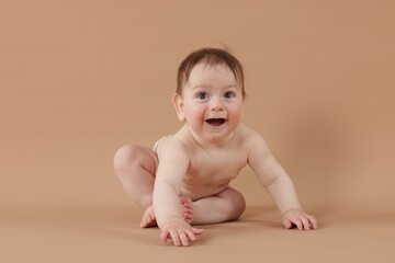 Cute little baby crawling on beige background