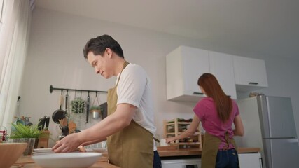 Asian young couple enjoying their daily housework routine together. 
