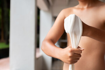 Close-up of a young Muay Thai fighter wrapping his hand with traditional cloth. The image captures detail and texture, highlighting strength, focus, and cultural authenticity.